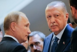 FILE - Russian President Vladimir Putin (L) and Turkish President Recep Tayyip Erdogan wait to enter a hall during their meeting at the Bocharov Ruchei residence in the Black Sea resort of Sochi, Russia, Sept. 17, 2018.