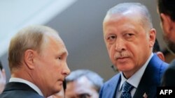 Ba Perezida w'Uburusiya na Vladimir Putin, ibiryo, n'uwa Turukiya Recep Tayyip Erdogan barindiriye kwinjira gusinya amasezerano. Itariki 17/09/2018. 