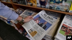 A man picks up a Spanish newspaper reporting on President-elect Joe Biden winning the US presidential election, in Pamplona, northern Spain, Nov. 8, 2020. 