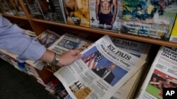 A man picks up a Spanish newspaper reporting on President-elect Joe Biden winning the US presidential election, in Pamplona, northern Spain, Nov. 8, 2020. 