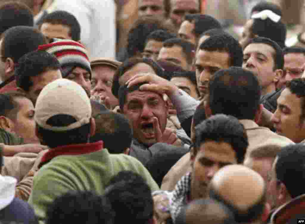 Anti-government demonstrators grab a man, center, they suspect to be a supporter of Egyptian President Hosni Mubarak in Cairo's Tahrir Square, Egypt, Thursday, Feb. 3, 2011. The Egyptian military is taking up positions between anti-government demonstrato