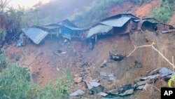 A landslide damages houses in a village in Phuoc Loc district, Quang Nam province, Vietnam Thursday, Oct. 29, 2020. 