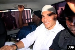 FILE - Karim Wade, son of former Senegalese President Abdoulaye Wade, arrives at a courthouse in Dakar, Senegal, flanked by two prison guards on July 31, 2014, for the start of his trial for charges of illicit enrichment.