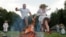 People jump over a campfire as they take part in the Ivan Kupala festival in Belarusian state museum of folk architecture and rural lifestyle near the village Aziarco, July 4, 2020.