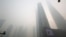 An electronic screen and buildings are seen amid heavy smog at the financial district of Pudong in Shanghai, Dec. 6, 2013.