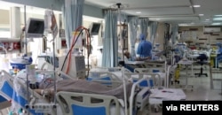 FILE - Patients with coronavirus disease (COVID-19) lie in beds at the ICU of Sasan Hospital, in Tehran, Iran, March 30, 2020.