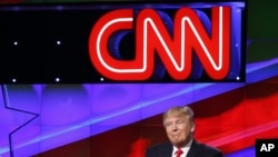 FILE - Then-presidential candidate Donald Trump is pictured beneath the CNN logo at a Republican candidates debate, sponsored in part by the cable news organization, at the University of Miami, March 10, 2016, in Coral Gables, Fla. 