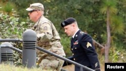 Çavuş Bergdahl (sağda) Kuzey Carolina'daki Fort Bragg askeri üssünde mahkemeye götürülürken