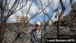 Seorang pria mengamati area yang terbakar akibat kebakaran hutan yang melanda wilayah Tartus, Suriah, pada 11 Oktober 2020. Kebakaran hutan melanda beberapa wilayah Suriah dan Lebanon pada 2020. (Foto: AFP/Louai Beshara)