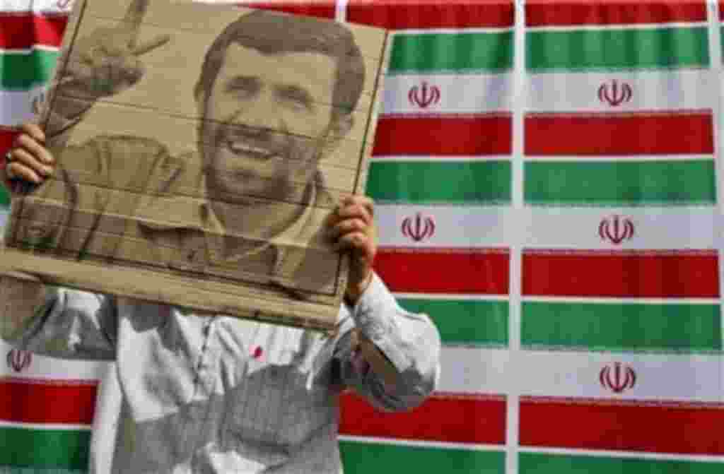 A supporter of hard line president and candidate for presidential elections Mahmoud Ahmadinejad holds the president's poster during the final rally on Azadi street in front of the Sharif university mosque in west Tehran, Wednesday, June 10, 2009. (AP Pho