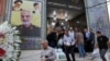 Ljudi napuštaju džamiju u dominantno iračkom južnom kraju Teherana, 30. jula 2019. Na zidu se vidi poster sa likom generala Kasema Sulejmanija, zajedno sa vrhovnim liderom Ali Hameneijem i ajatolom Homeinijem.