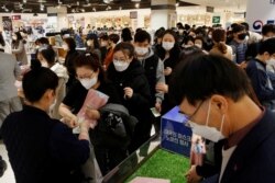 Warga Korea Selatan antri di sebuah pusat perbelanjaan di Seoul untuk membeli masker (27/2).