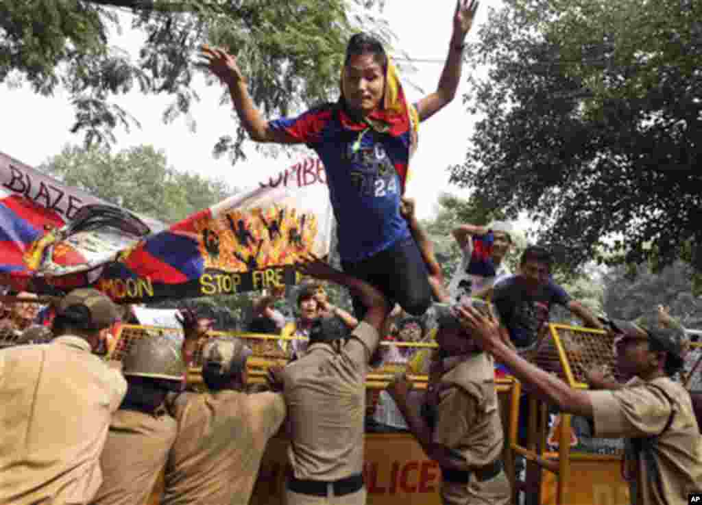 An exile Tibetan jumps over a police barricade outside the United Nations Information Center at a protest seeking U.N. intervention in the Tibet issue in New Delhi, India, Monday, Oct. 24, 2011.