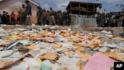 Kertas-kertas berserakan sementara warga berkumpul pasca robohnya gedung sekolah "Precious Talent Top School" di Nairobi, Kenya, hari Senin (23/9). 