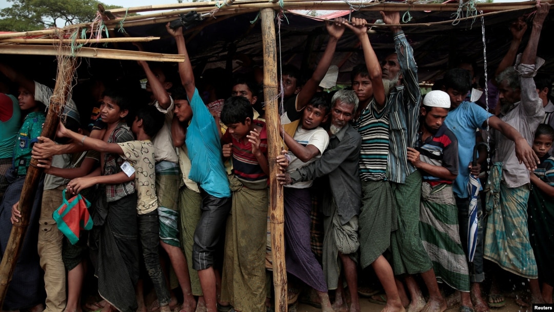 Rohingya refugees jostle as they line up for a blanket distribution under heavy rainfall at the Balukhali camp near Cox's Bazar, Bangladesh, Dec. 11, 2017.