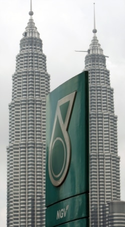 FILE - A Petronas logo is seen near its twin towers in Kuala Lumpur, Malaysia.