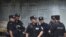 Chinese policemen huddle near the Chengdu Intermediate People's Court in Chengdu in southwest China's Sichuan province, Sept. 17, 2012.