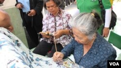 Proses pembuatan batik tulis bertema mangrove oleh perajin dan kader lingkungan Kecamatan Rungkut Surabaya (Foto: VOA/Petrus Riski)