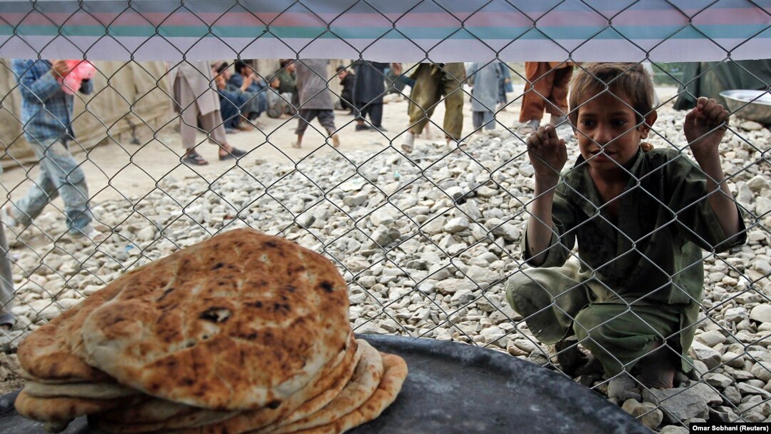 Seorang anak laki-laki Afghanistan menunggu makanan yang didistribusikan oleh Kementerian Dalam Negeri Afghanistan kepada keluarga pengungsi internal dari provinsi Helmand, selama bulan suci Ramadhan di sebuah kamp pengungsi di Kabul. (Foto: REUTERS/Omar 