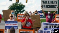 Sister Barbara Battista speaks to death penalty protesters across the street from the federal prison complex in Terre Haute, Ind., Aug. 26, 2020. Lezmond Mitchell was later put to death in the prison for two killings that occurred nearly two decades ago.