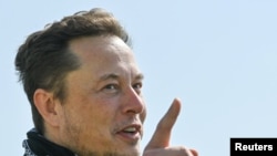 FILE PHOTO: Tesla CEO Elon Musk gestures as he visits the construction site of Tesla's Gigafactory in Gruenheide near Berlin, Germany, August 13, 2021. Patrick Pleul/Pool via Reuters/File Photo