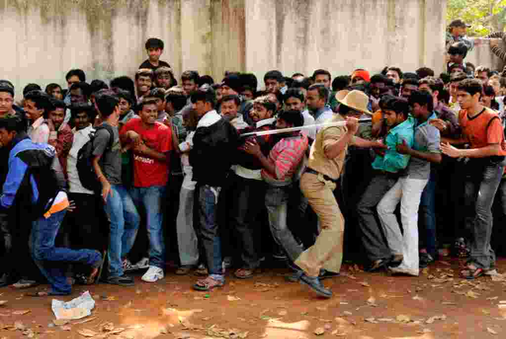 A policeman moves men back into a queue for tickets for the India and England Group B cricket World Cup match at the M. Chinnaswamy Stadium in Bangalore. (Reuters/Philip Brown)