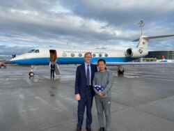 FILE - Chinese American academic Xiyue Wang, released by Iran after three years in jail as part of a prisoner swap with the U.S., stands with U.S. Special Representative for Iran Brian Hook at Zurich airport, Dec. 7, 2019.