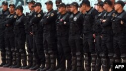 Tunisian riot police stand guard at the stadium of Rades, near Tunis, during a football match, Feb. 21, 2016, as the Tunisian government extended the state of emergency begun November 2015.