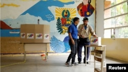 Miembros de un centro de votación en una escuela de Caracas instalan las mesas para la elección presidencial del domingo, este viernes 26 de julio de 2024.