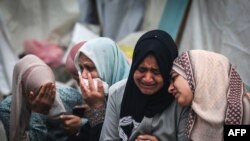 FILE - Palestinians mourn their relatives, killed in an overnight Israeli strike on the Al-Maghazi refugee camp, during a mass funeral at the Al-Aqsa hospital in Deir Al-Balah, in the southern Gaza Strip, on December 25, 2023, amid ongoing battles betw