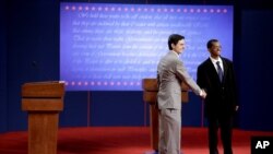 周二在丹佛大学进行首场辩论会的彩排中，罗姆尼和奥巴马的替身握手 