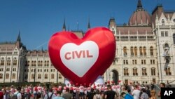 Activists of Amnesty International and other civil groups hold a solidarity demonstration to protest against the Hungarian government's package of bills dubbed 'Stop Soros' at the House of Parliament in Budapest, Hungary, June 4, 2018. 