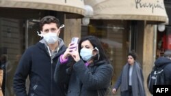 FILE - Tourists with protective mask visit Florence on Feb. 25, 2020 as Tuscany reported its first two cases of COVID-19.