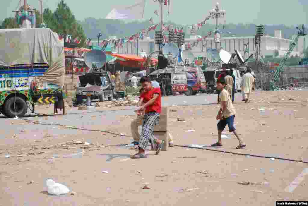 شاہراہ دستور پر دن کے وقت بچے کرکٹ کھیل رہے ہیں۔