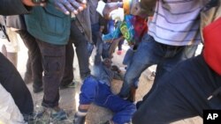A police officer is assaulted by angry protesters in Harare, Monday, July, 4, 2016. (AP Photo/Tsvangirayi Mukwazhi)