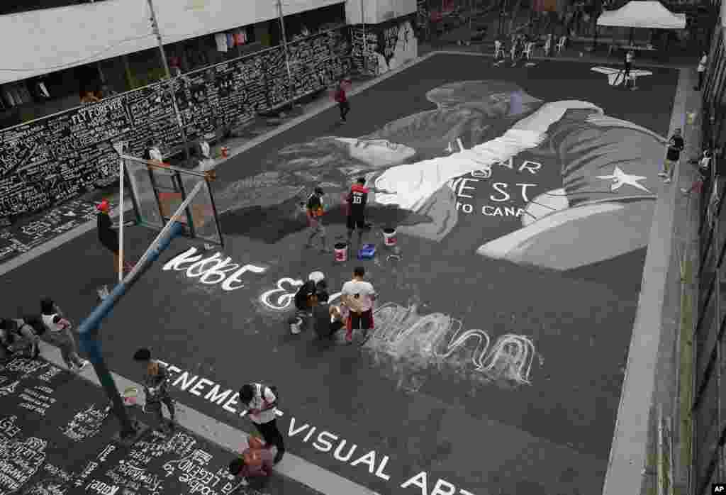 Artists put on the finishing touches on a giant painting of former NBA basketball player Kobe Bryant and his daughter Gianna at a basketball court in Taguig, south of Manila, Philippines.