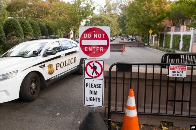 An officer with the Uniform Division of the United States Secret Service sits in his car at a checkpoint near the home of President Barack Obama, Oct. 24, 2018, in Washington.