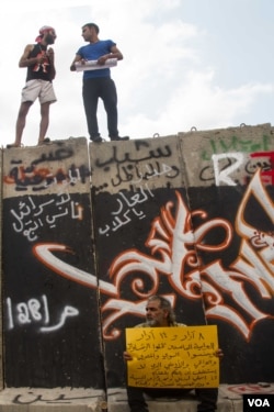 Protesters quickly covered the wall in graffiti and images. (Credit: John Owens/VOA)
