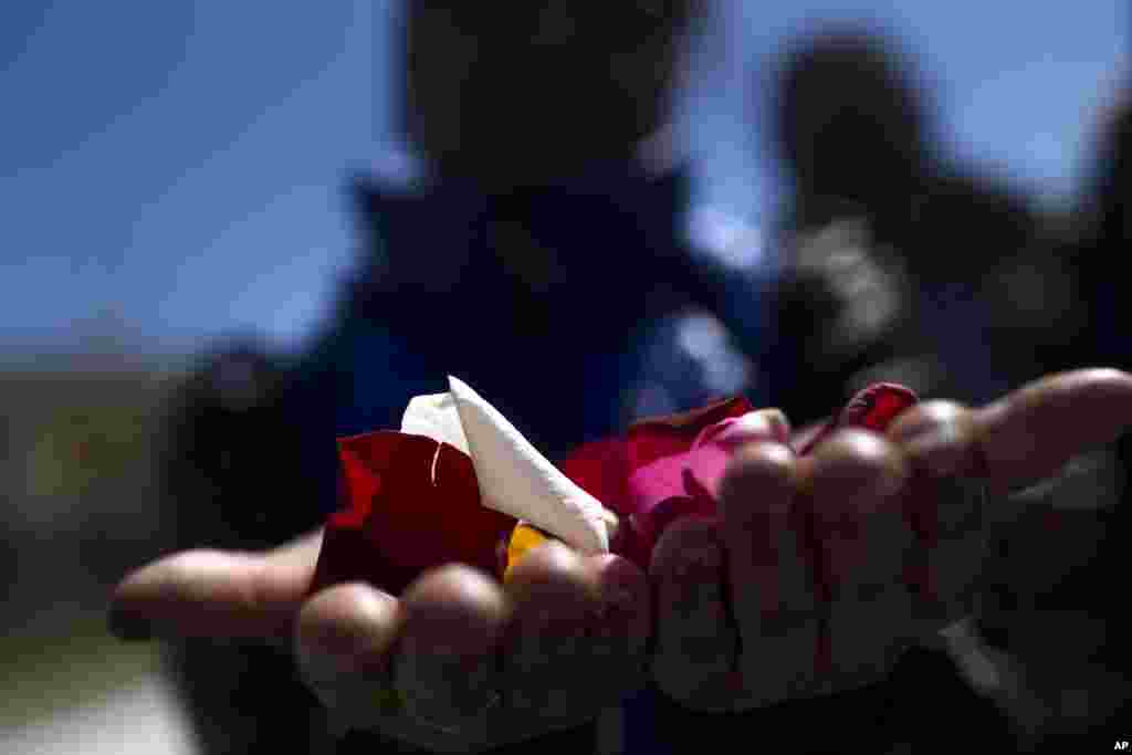 A woman holds flower petals in her hands before throwing them into the Manzanares river during an event marking International Roma Day in Madrid. Members of Spain's gypsy community held the ceremony to symbolize the departure of their ancestors from India and their exodus across the world.