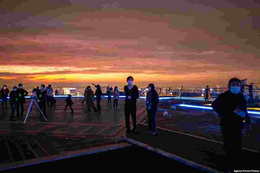 People gather to observe a lunar eclipse from the observation deck of Roppongi Hills in Tokyo on Nov. 19, 2021.