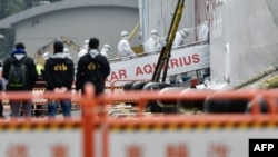 台灣中央流行疫情指揮中心工作人員身穿防護服登上基隆港的寶瓶星號遊輪。 （2020年2月8日）