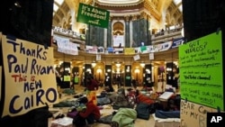 Opponents to the governor's bill to eliminate collective bargaining rights for many state workers sleep on the floor of the rotunda at the state Capitol in Madison, Wisconsin, at the start of the tenth day of protests, February 24, 2011