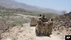 In this May 1, 2014 photo provided by Yemen's Defense Ministry, army vehicles patrol a road during fighting with al-Qaida militants in Majala of the southern province of Abyan, Yemen. 