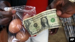 A man buys eggs using a U.S. one dollar bill at a market in Harare (File)