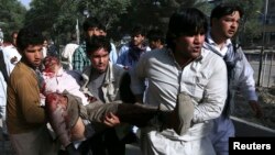 Men carry a man who was wounded during a suicide car bomb attack in Kabul June 11, 2013.