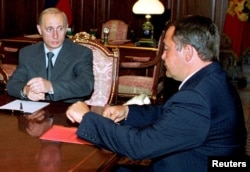 俄罗斯总统普京(左)2000年8月28日听取当时的传媒部长汇报有关事件事态发展