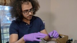 In this 2020 photo provided by the University of California, San Francisco, researcher David Moses works with clinical trial participant 