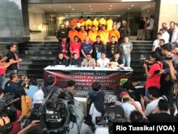 Humas Polda Metro Jaya Argo Yuwono (tengah) berbicara kepada wartawan seraya menunjukkan para tersangka dan sejumlah barang bukti demonstrasi ricuh 22 Mei. (VOA/Rio Tuasikal)