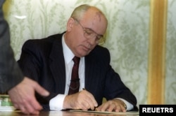 1991年12月25日，苏联总统米哈伊尔·戈尔巴乔夫 (Mikhail Gorbachev) 在国家电视台的现场讲话前几分钟签署辞呈。次日苏联宣告解体。（路透社图片）
