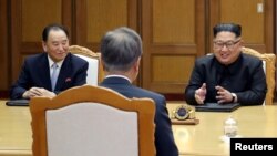Kim Yong Chol, left, sits next to North Korean leader Kim Jong Un during talks with South Korean President Moon Jae-in during their summit at the truce village of Panmunjom, North Korea, May 26, 2018. 